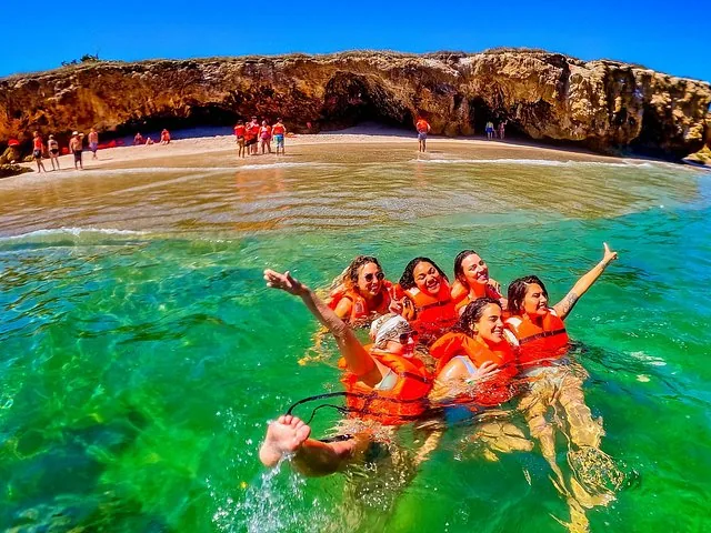 Eine Gruppe Frauen in Schwimmwesten schwimmt und posiert im Wasser